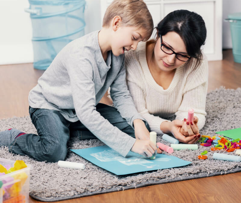 kid and behavior technician working on floor